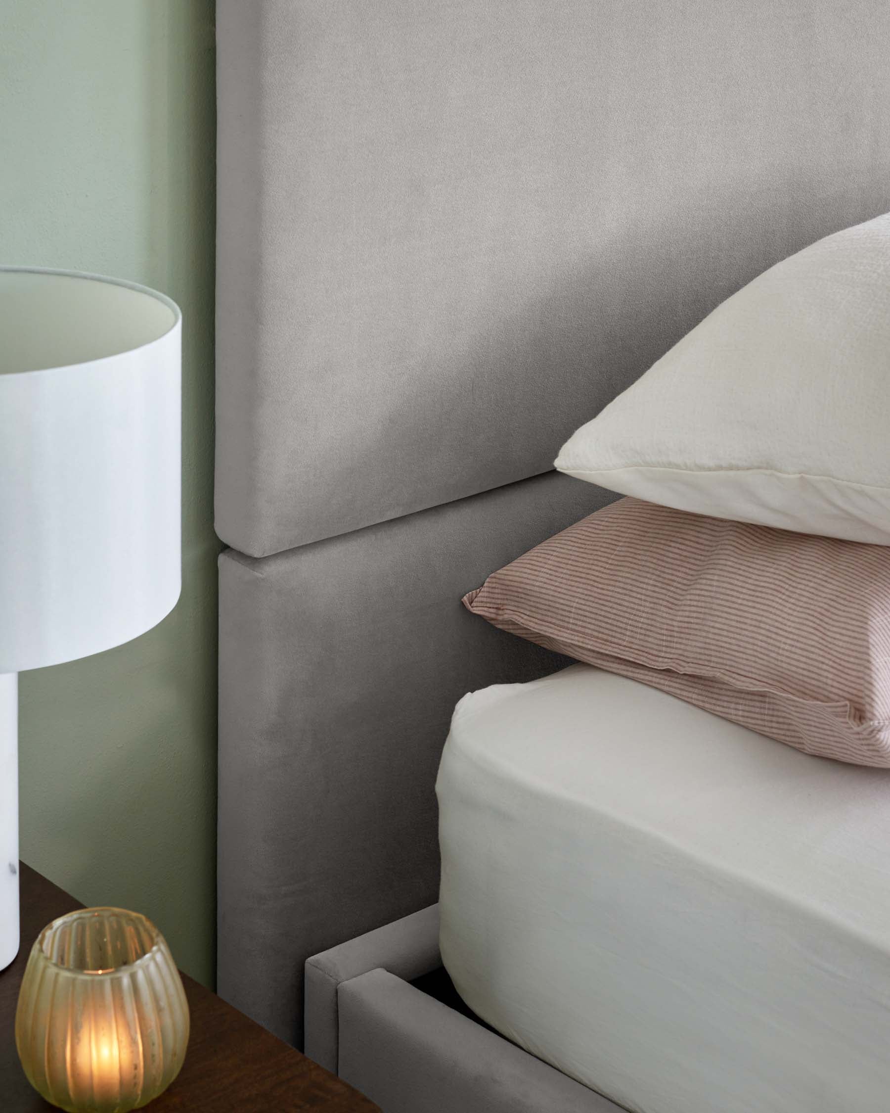 Lit coffre Penelope en velours gris clair, format king, avec tête de lit à 3 panneaux.