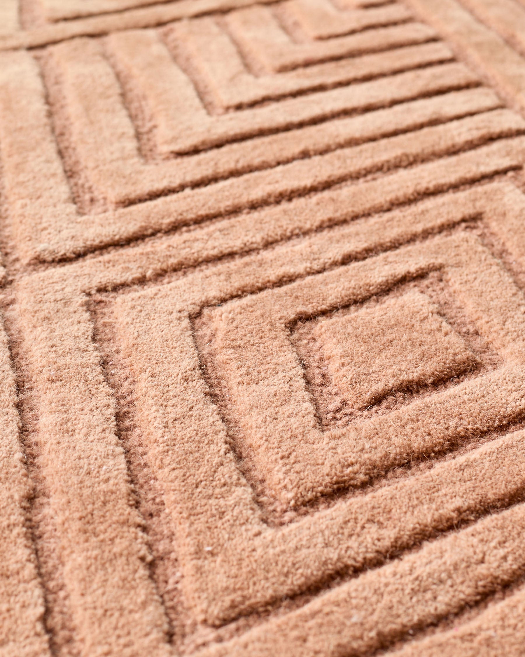 Grand tapis texturé en terre cuite à motifs abstraits