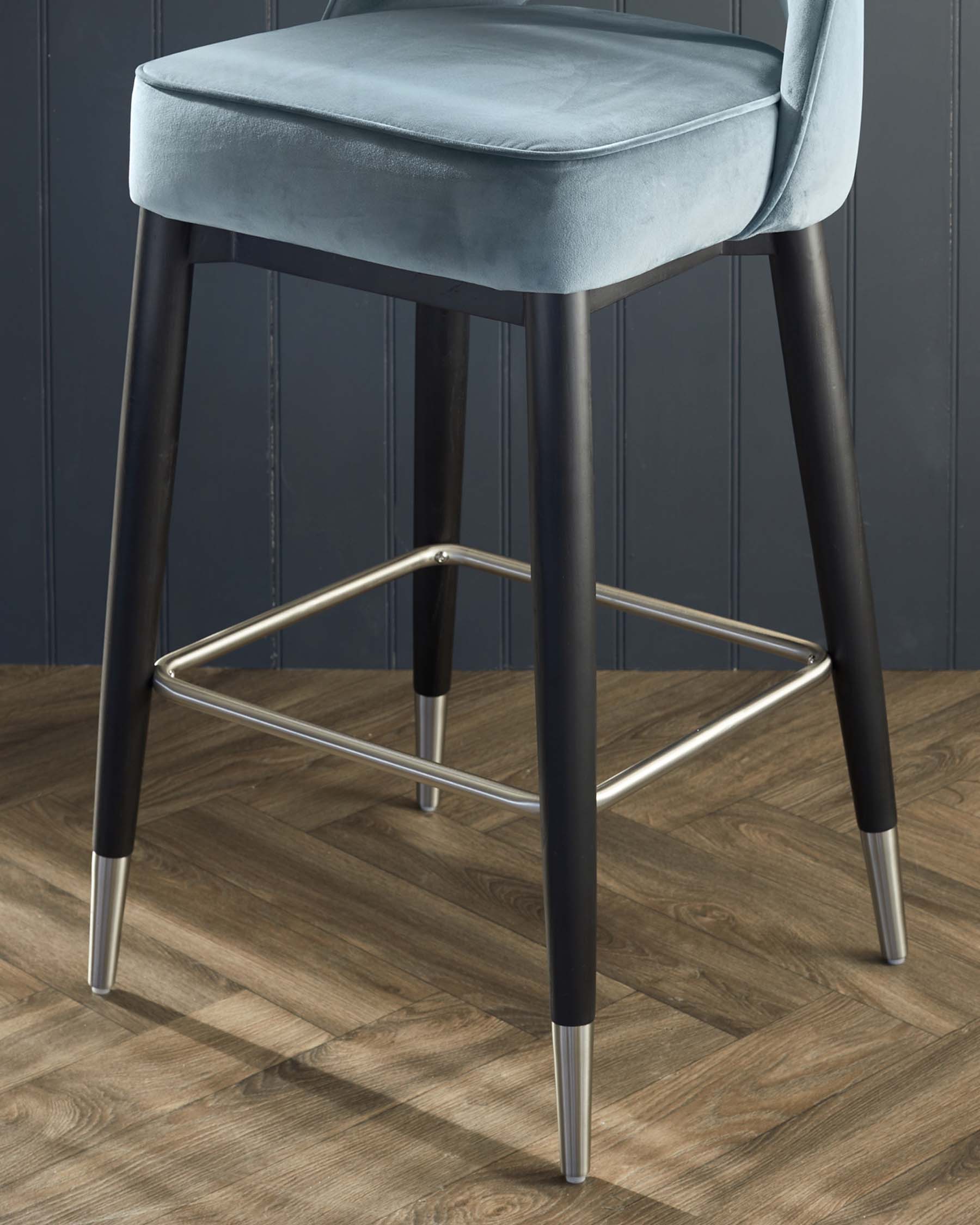 Tabouret de bar Clover en bois noir avec embouts en acier inoxydable, recouvert de velours peluche bleu-gris.