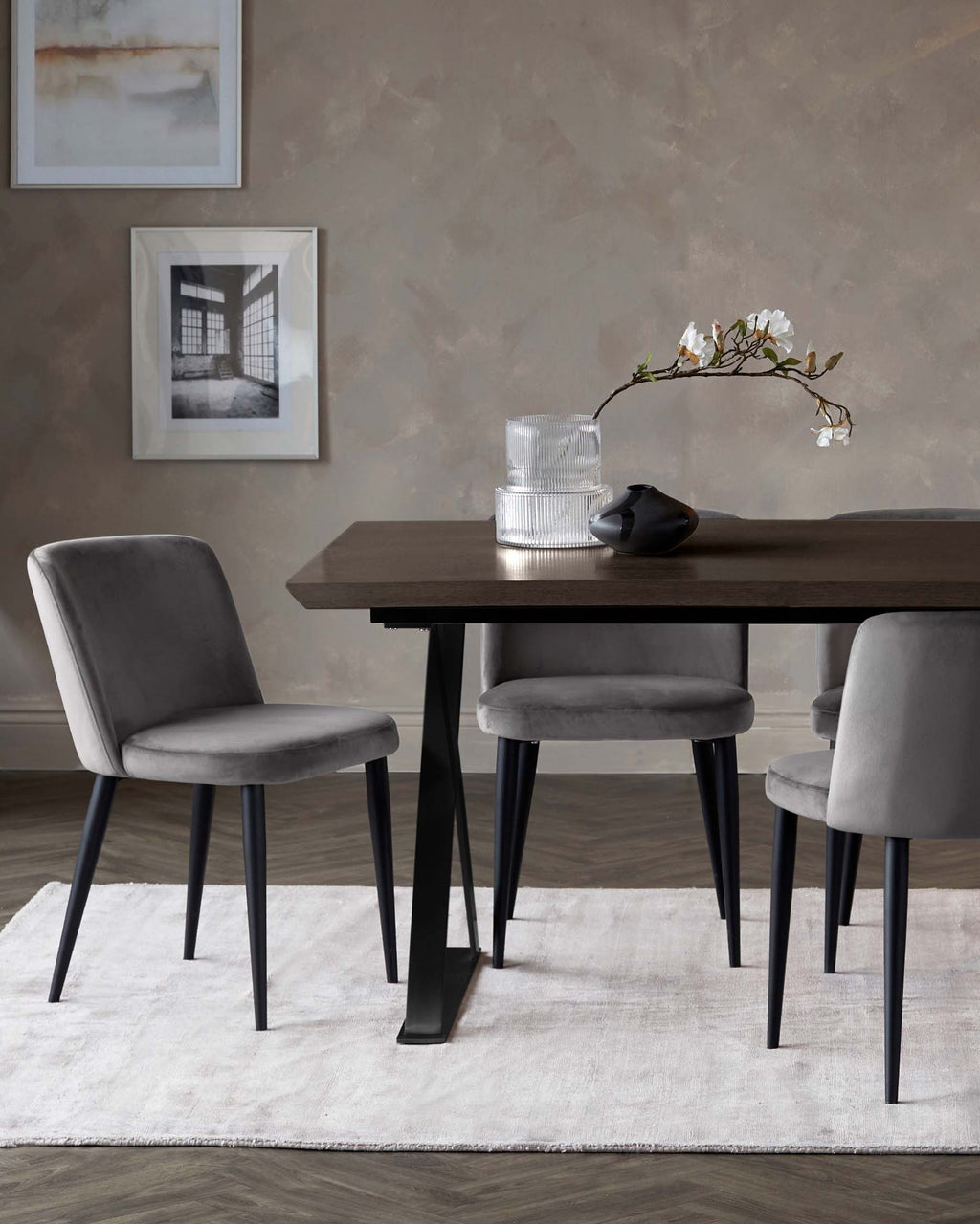 Chaise de salle à manger Trinny en métal noir, revêtue de velours gris foncé.